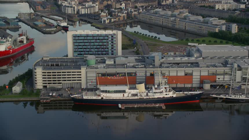 Large boat docked in the harbor next to a city