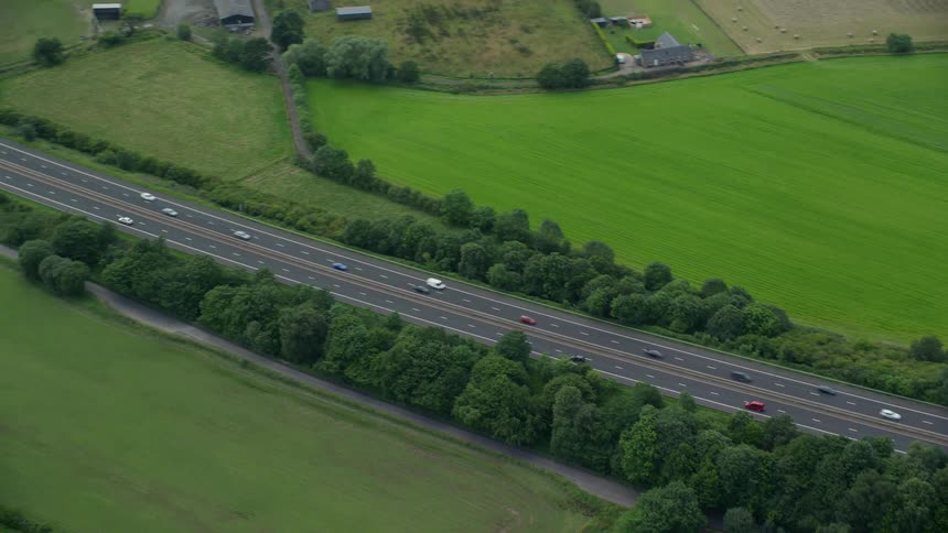 Aerial view of vehicles driving on a highway through the countryside