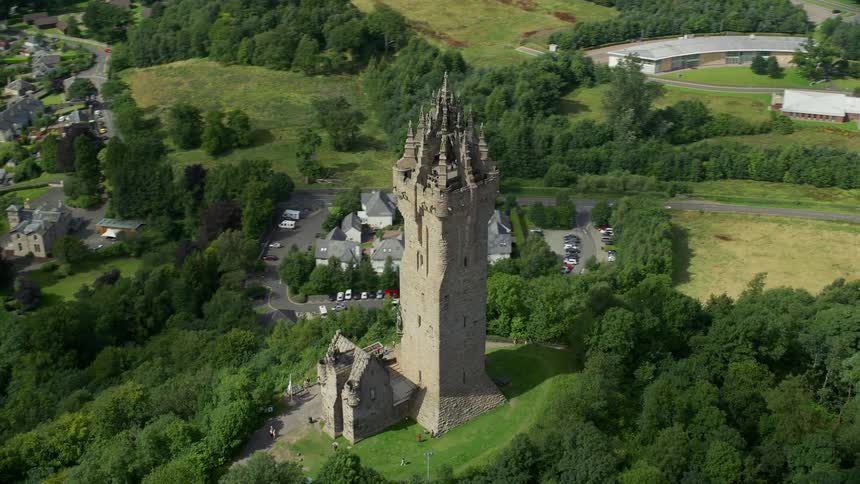 Aerial of an ancient tower atop a hill next to a town