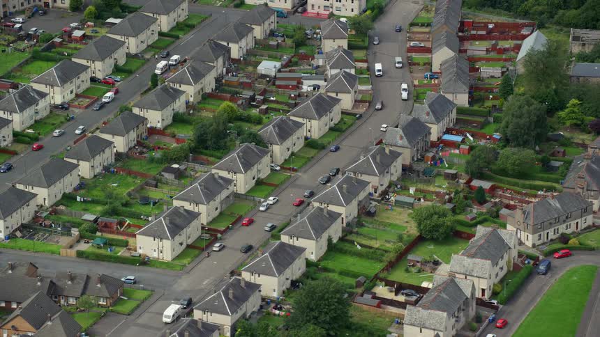 Aerial of a suburban neighborhood with houses and streets with cars parked on them