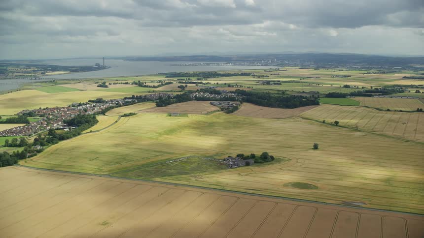 Aerial of extensive crop fields in the plains next to a lake