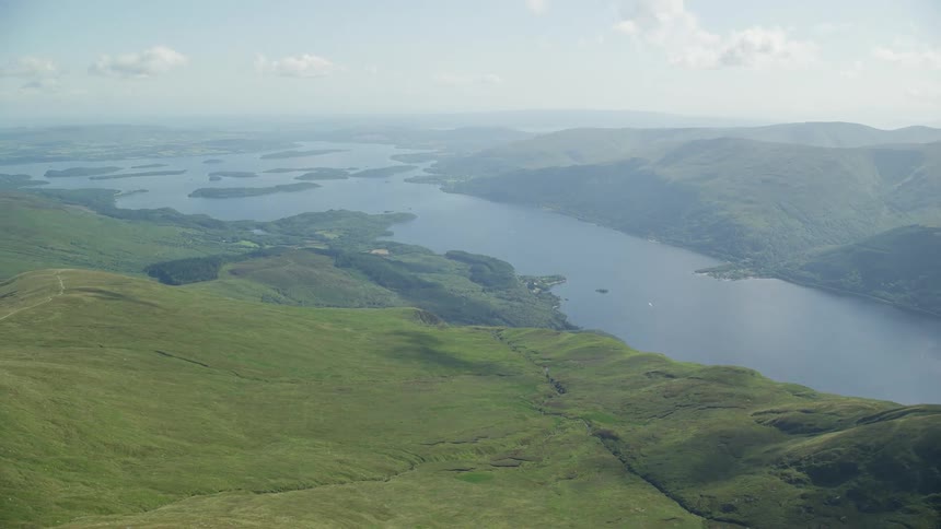 A view of mountains of grass and a huge river in the middle crossing the horizon
