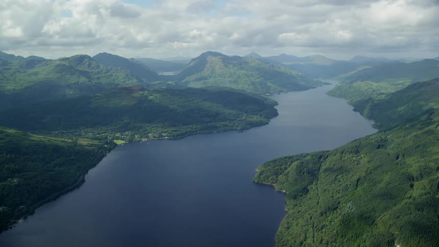 A wide open view of a landscape with mountains and a river