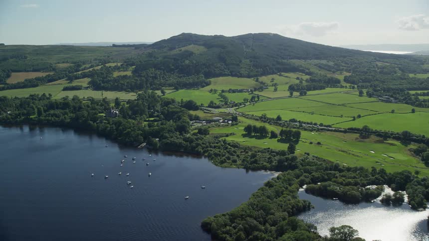 Aerial view of pastures mountains by the sea and boats