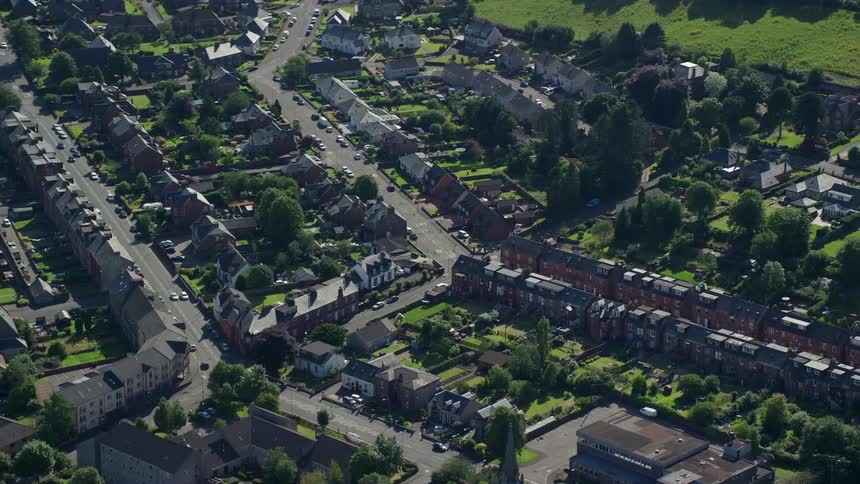 Aerial of a suburban neighborhood with houses built close together and small yards with trees