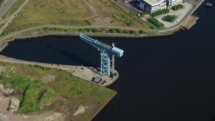Drone view land and buildings and a crane near the water