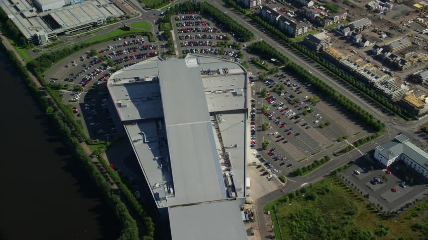 Vehicles fill a parking lot outside a factory