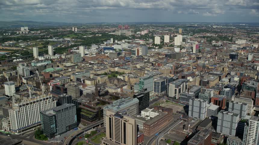 An aerial of the downtown area of a large city under mostly cloudy skies