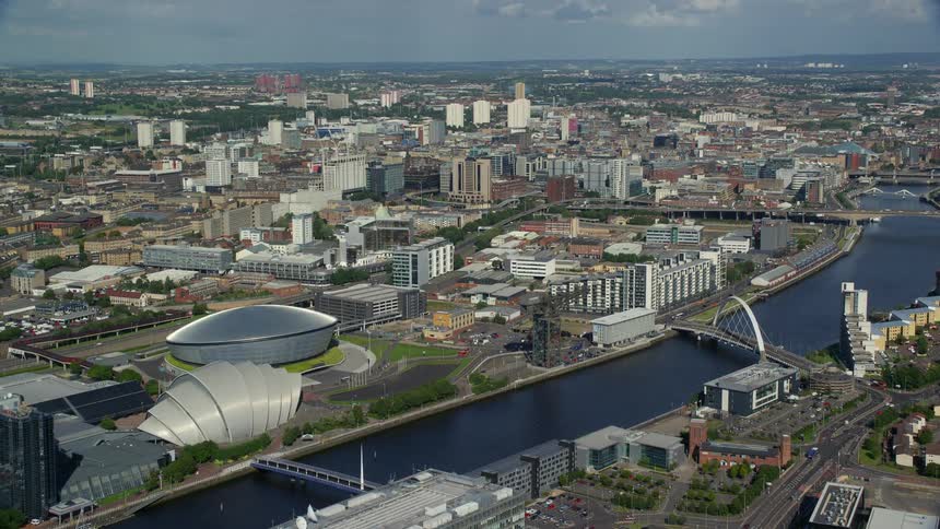 Aerial shot of metropolitan cityscape with buildings and roads next to the river during day time