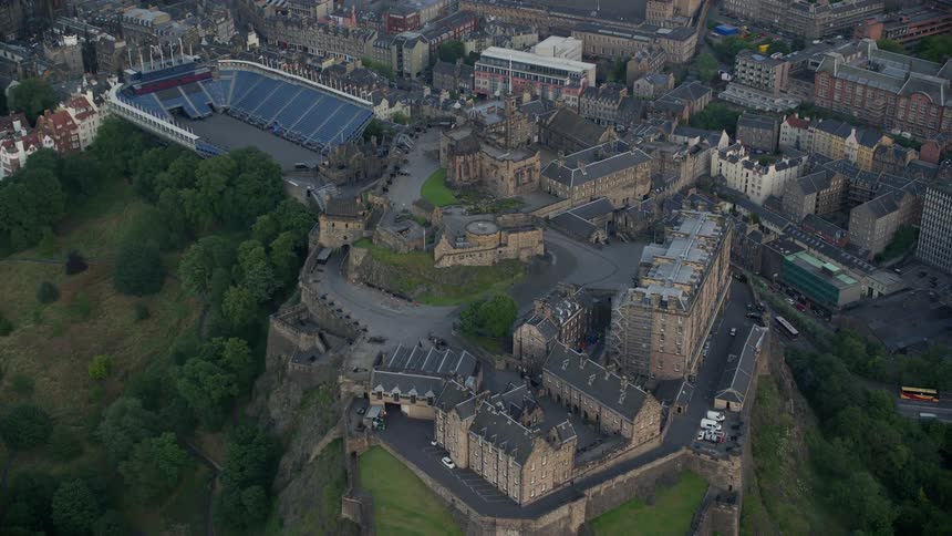 Aerial view of a historic monument and a stadium built on top of a hill in the middle of the city