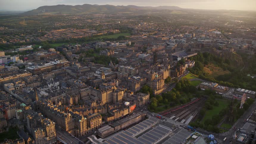 Aerial of a city with old buildings on grassland at sunrise