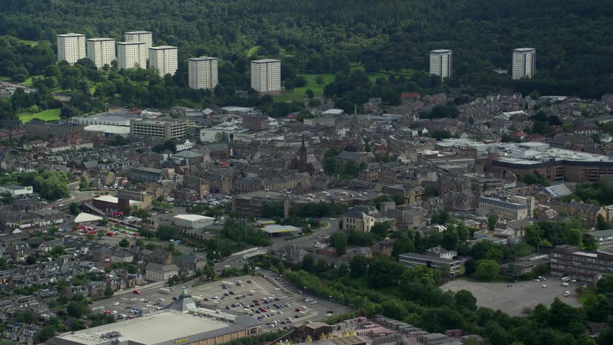 Aerial view of an urban city with several buildings and lush vegetation around