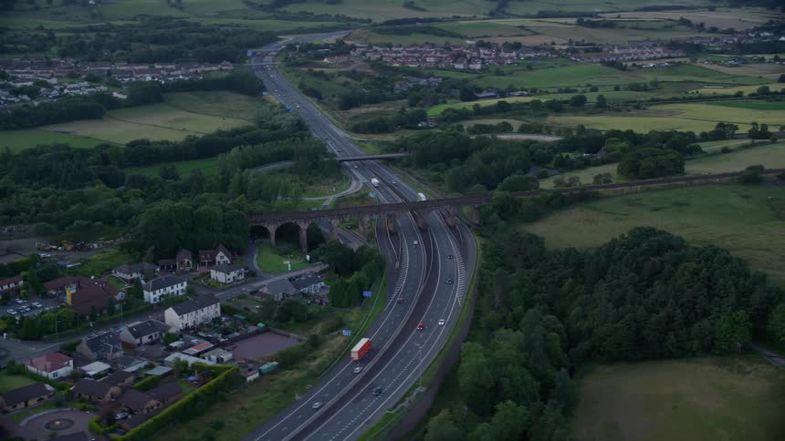 Aerial view of a rural region with fields houses and a central highway