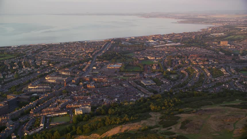 Aerial view of an urban city on the coast with mountains in the surroundings