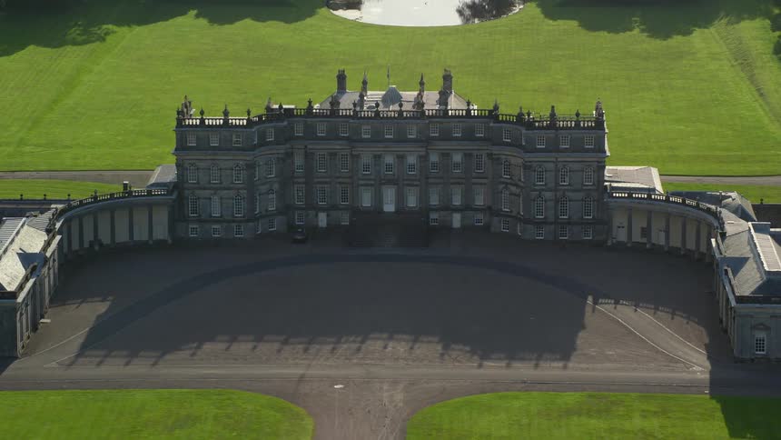 Aerial view of a massive mansion in a location with abundant vegetation