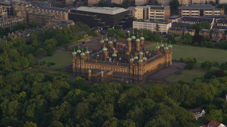 Aerial of an architectural building in a metropolitan area surrounded by lush forest trees