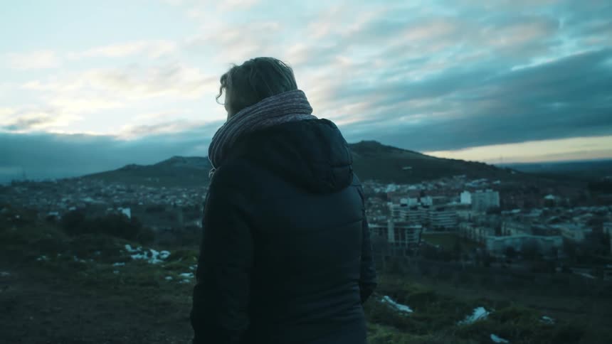 A person admiring the cityscape at sunset