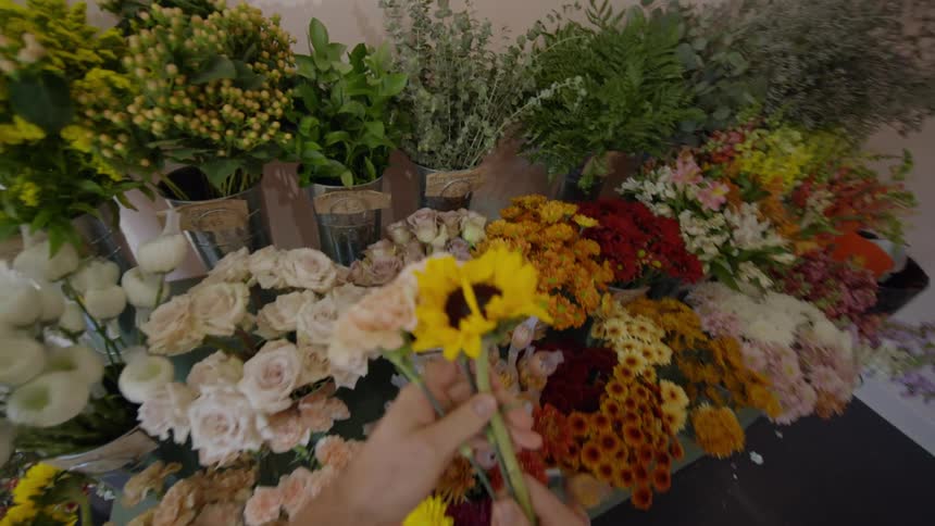 A person pickout individual flowers from an array of containers