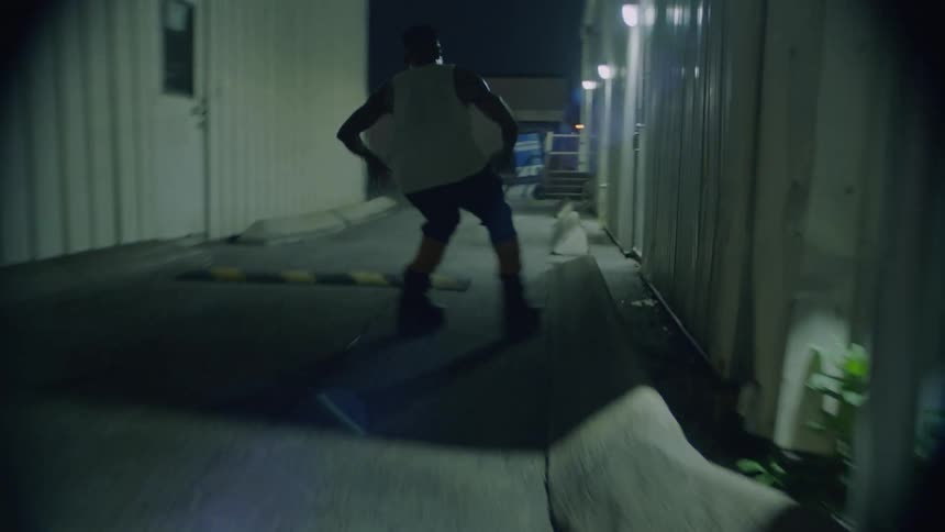 A man wearing roller blades skates quickly in between two buildings