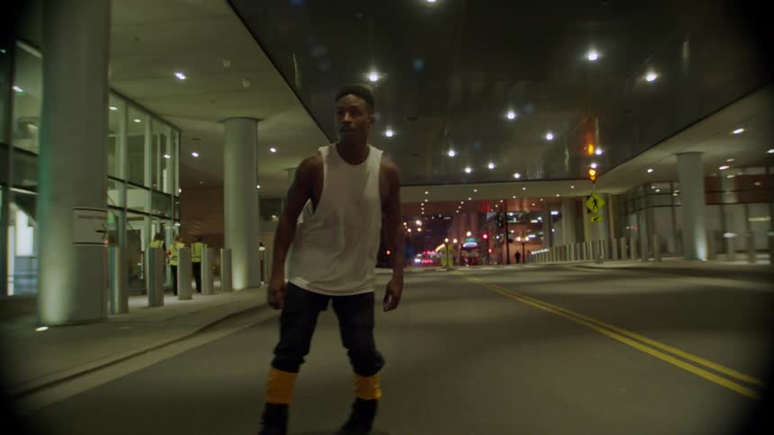 A man riding rollerblades on the city streets at night