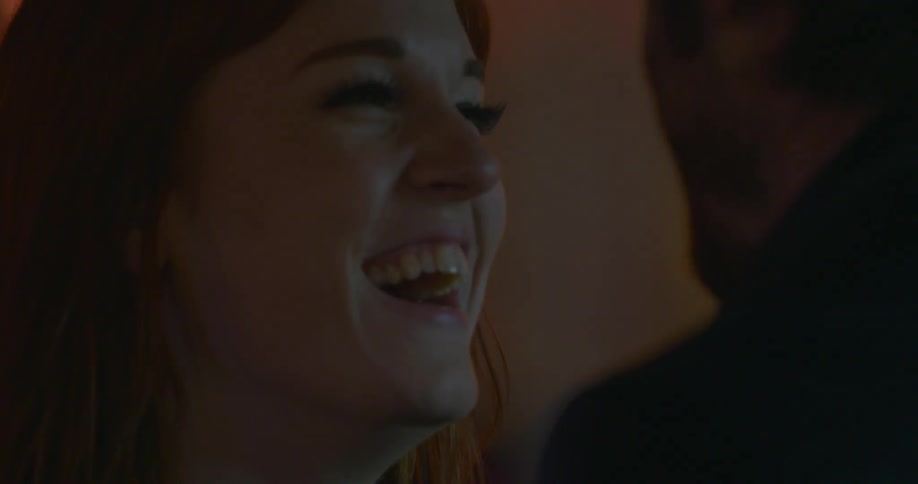 A woman is talking to a man and laughing