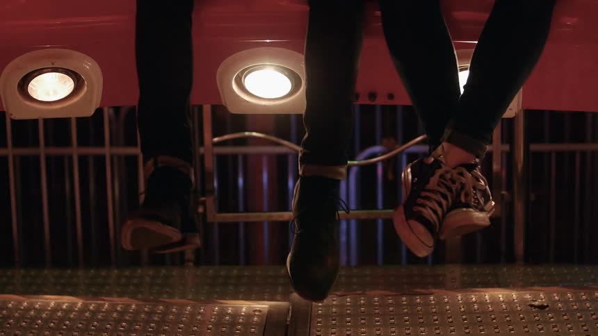 Two peoples legs are hanging over some lights