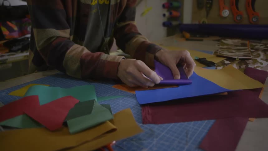A person places a piece of cut felt atop some other pieces while crafting