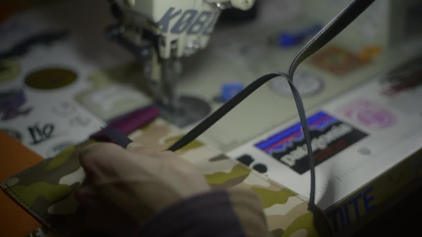 Close up of a person pulling ribbon apart from itself with their craft table in front of them