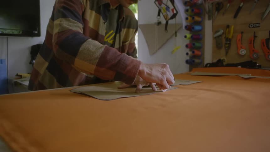A man outlining on a table in his work shop during the day