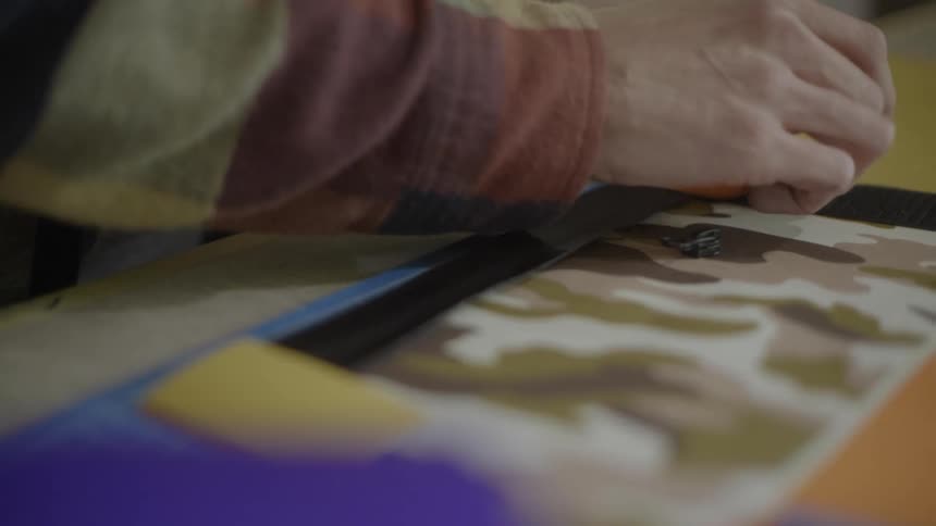 Hands of a person placing some colored papers on top of other papers