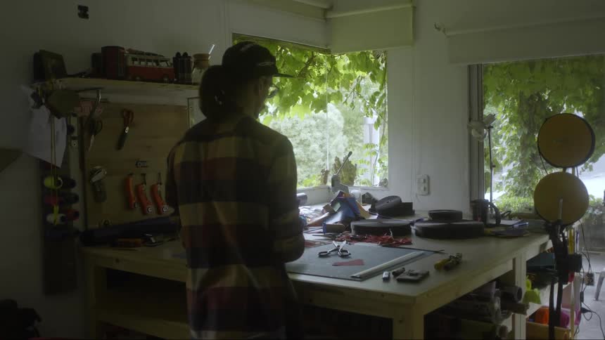 A man is standing near a sewing table