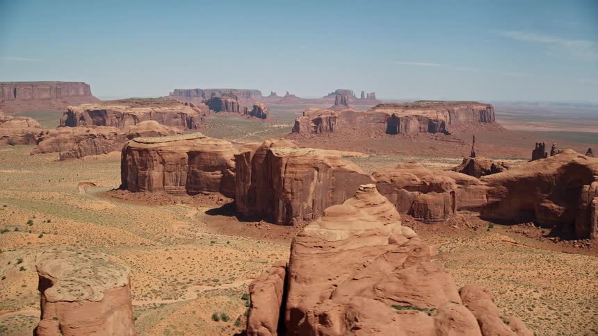 Aerial of a desert landscape with mountains and canyons during a hot day