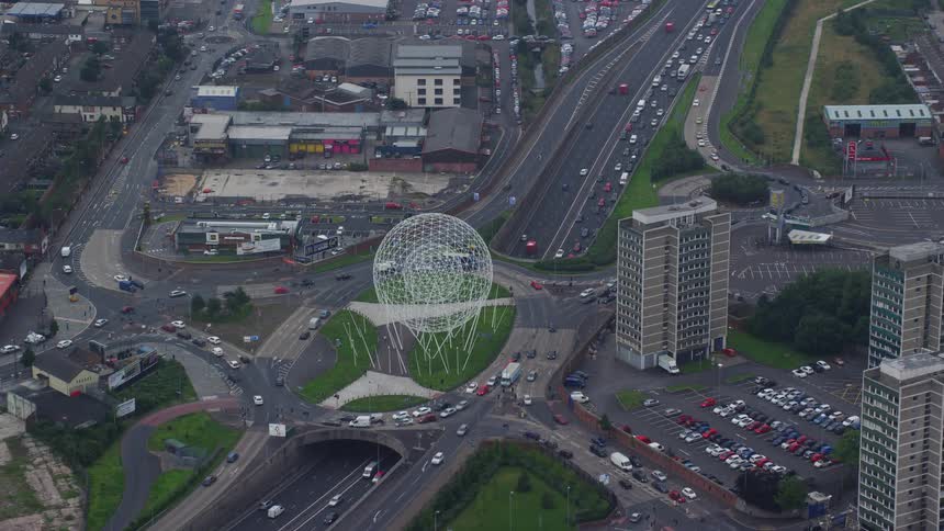Vehicles drive by white sphere in city center