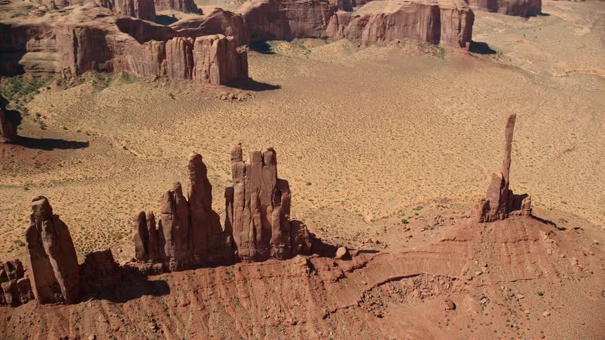 Rock formations stand tall among mesa in the desert