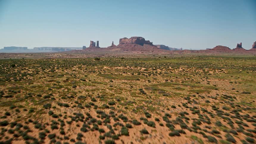 Scrub land borders mesas and plateaus on foggy horizon