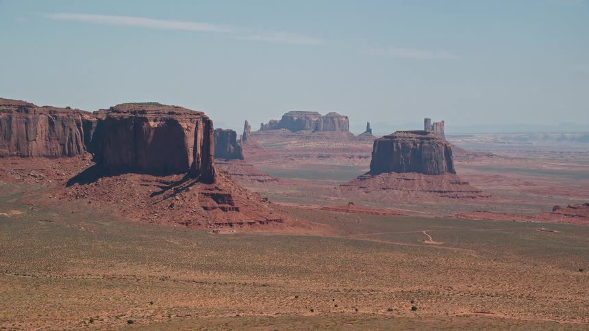 Rock formations and buttes stand tall among mesa on the desert landscape