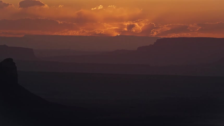 Aerial view of the sun rising behind the canyons