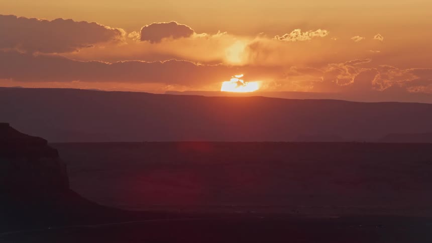 View of the sunrise with a reddish sky in a natural setting with a canyon