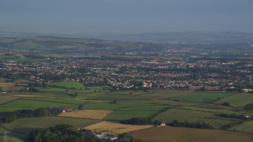 Aerial of a rural town with hectares of plantations during the day