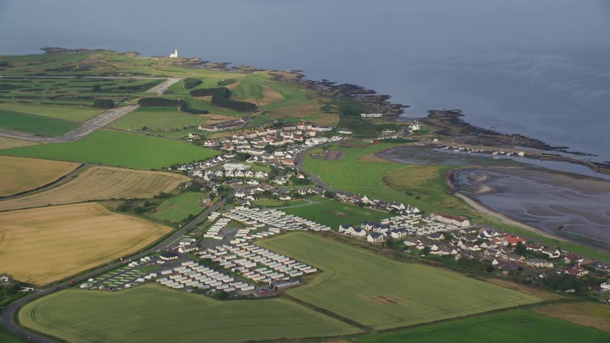 Small residential area amidst rural fields and by the seaside