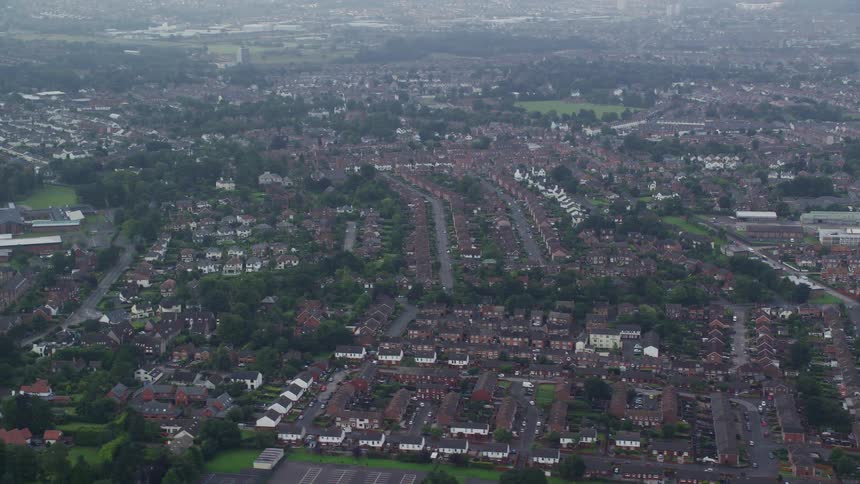 Aerial of buildings and trees in a suburban area at midday