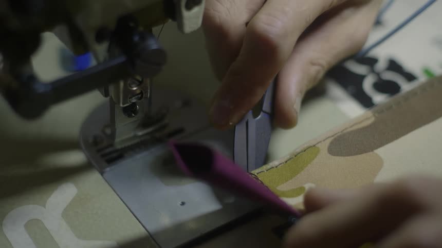 Hand cuts thread from fabric with scissors