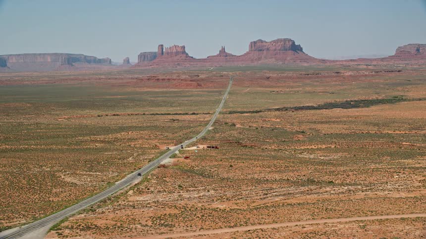 Aerial view of a road with vehicles traveling through a natural area with canyons valleys and rocky formations