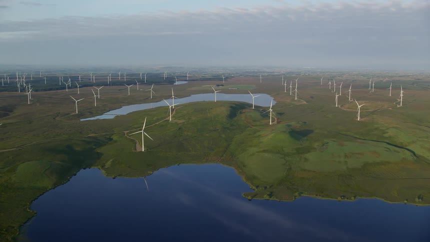 Aerial of a wind farm with small lakes in the landscape