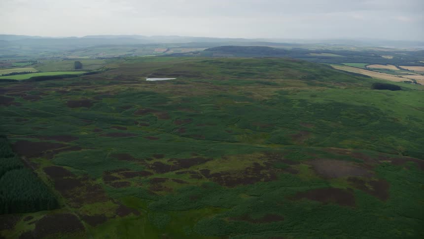 Aerial view of plains and mountains with forests and a lake