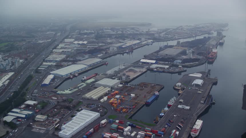 An industrial shopping area with marinas and boats and next to a busy road