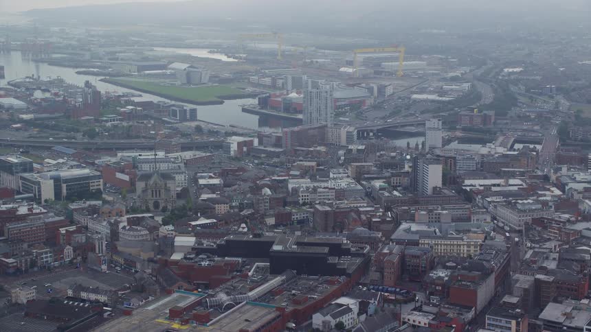 Traffic flows through city near waterfront on foggy day