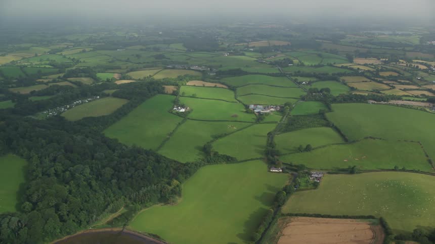Aerial view of a rural area with houses pastures and trees