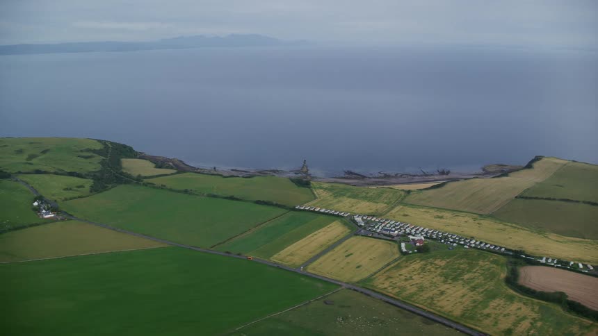Aerial view of farmlands on the coast next to the ocean