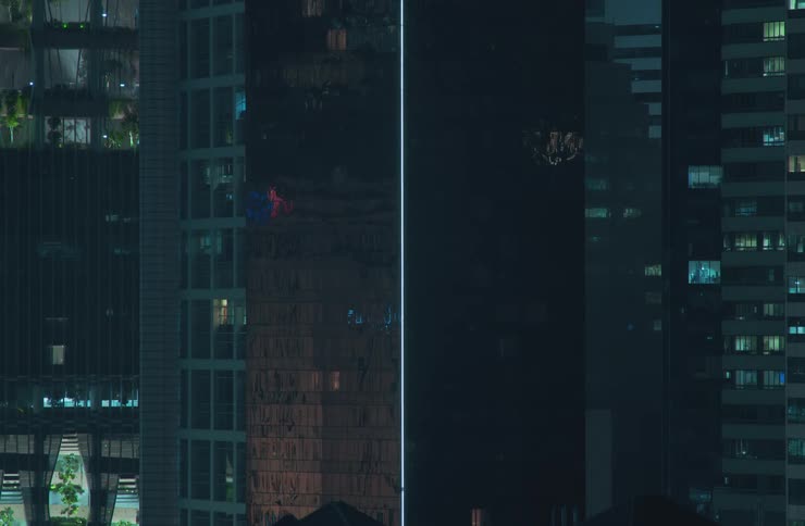 Lights from apartments of three skyscrapers at night turn on